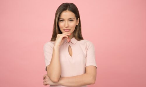 business woman standing against pink background